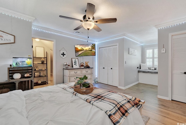 bedroom with a textured ceiling, ceiling fan, light hardwood / wood-style floors, and crown molding