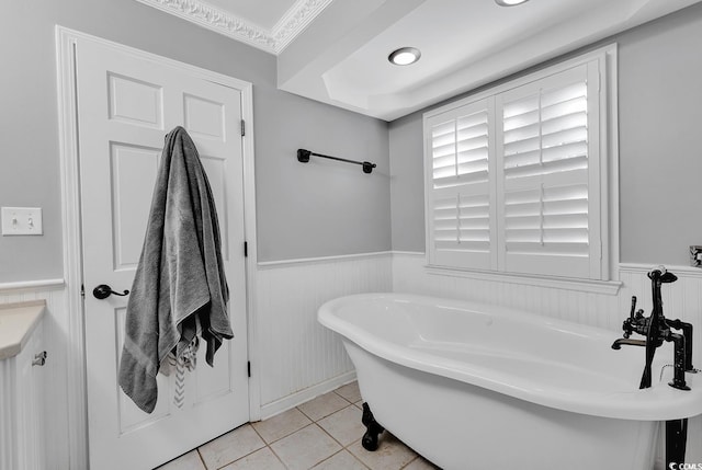 bathroom featuring vanity, tile patterned floors, a tub, and crown molding