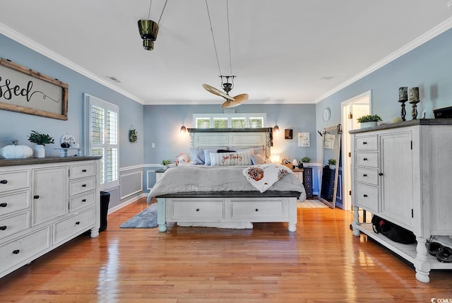 bedroom with multiple windows, light hardwood / wood-style floors, ceiling fan, and ornamental molding