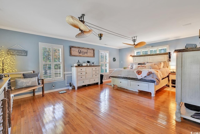 bedroom featuring ceiling fan, light hardwood / wood-style floors, and crown molding