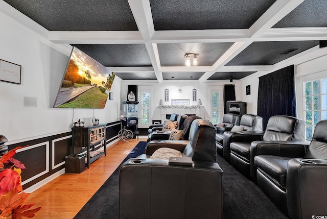 home theater room with hardwood / wood-style floors, beamed ceiling, coffered ceiling, and ornamental molding