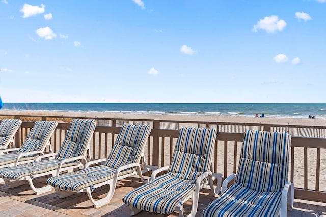 deck featuring a water view and a beach view