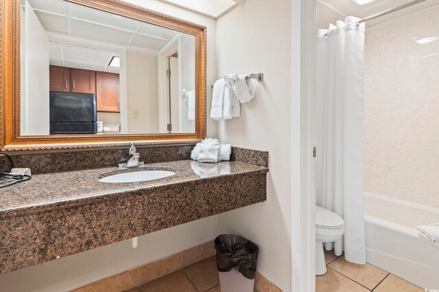 full bathroom with tile patterned flooring, toilet, shower / bathtub combination with curtain, and sink