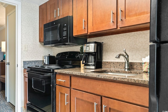 kitchen with black appliances, dark stone countertops, and sink