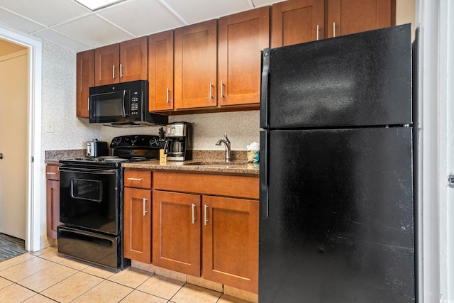 kitchen with light tile patterned floors, sink, a paneled ceiling, and black appliances