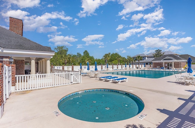 view of swimming pool with a patio and a hot tub