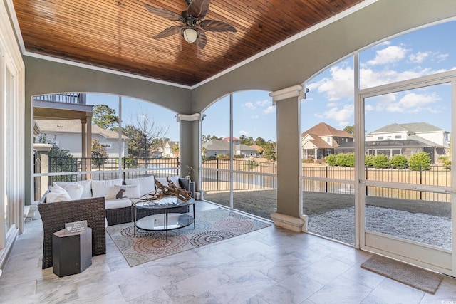 sunroom featuring ceiling fan and wooden ceiling