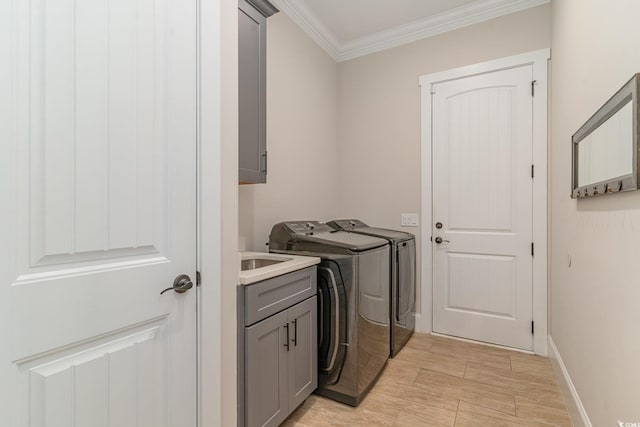 washroom with cabinets, washing machine and dryer, and crown molding