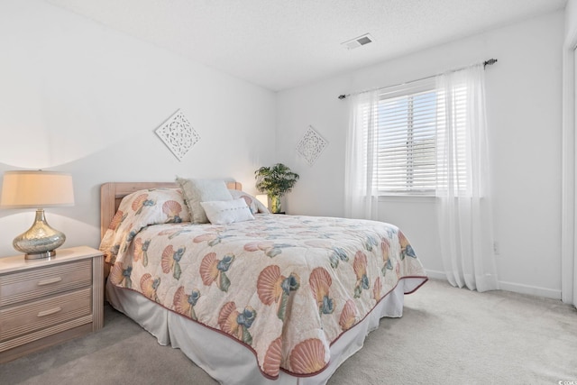 bedroom with a textured ceiling and light carpet