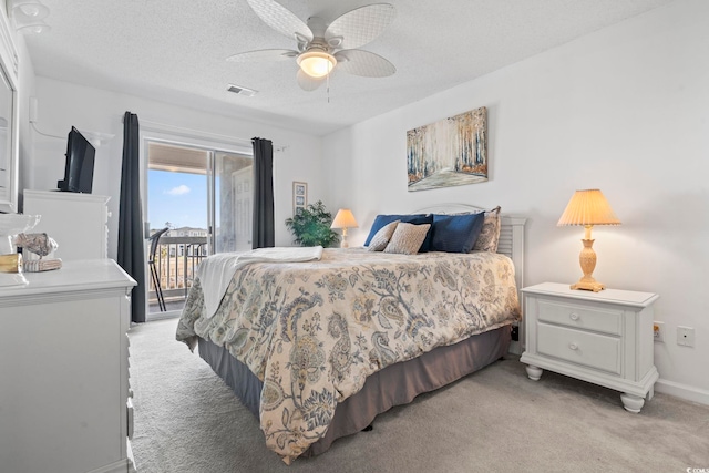 carpeted bedroom featuring access to outside, ceiling fan, and a textured ceiling