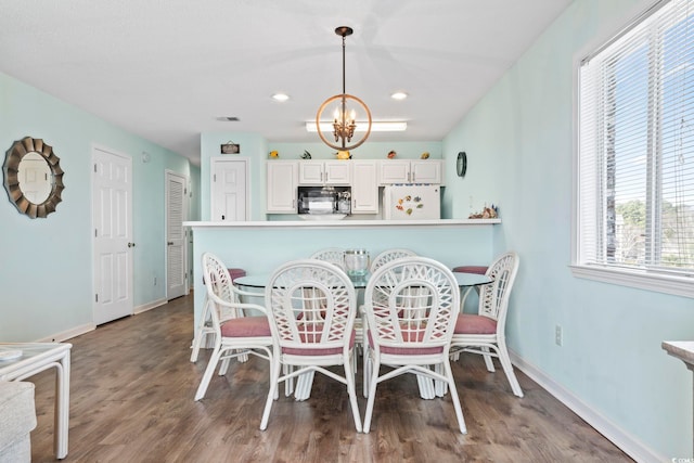 dining space with plenty of natural light, a chandelier, and hardwood / wood-style flooring