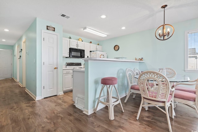 kitchen with white cabinets, kitchen peninsula, hanging light fixtures, and stainless steel electric range oven