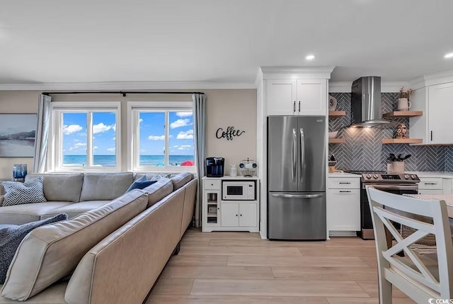 kitchen with white cabinets, wall chimney exhaust hood, a water view, and appliances with stainless steel finishes