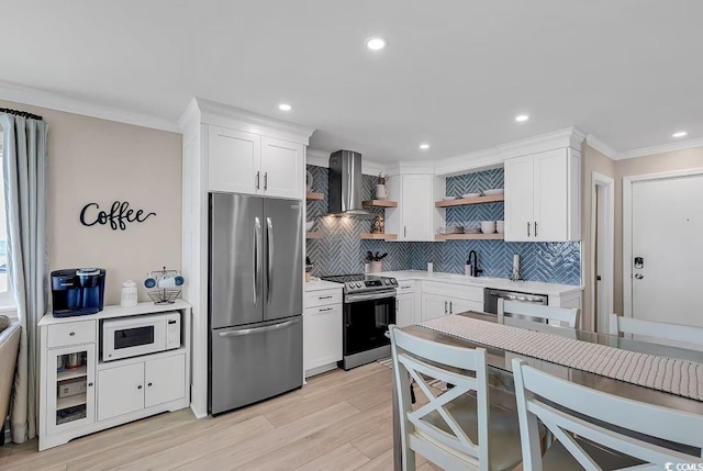 kitchen featuring white cabinetry, wall chimney range hood, and stainless steel appliances