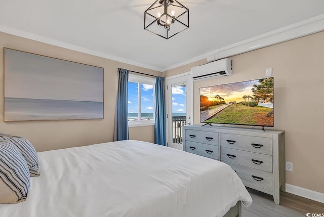 bedroom with an inviting chandelier, light hardwood / wood-style flooring, a wall mounted AC, crown molding, and access to outside