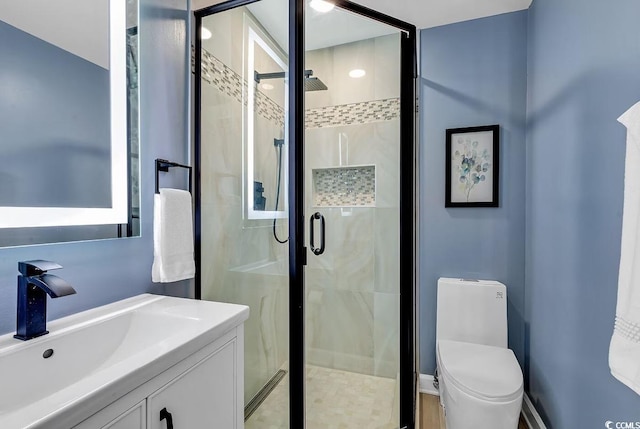 bathroom with vanity, an enclosed shower, and toilet