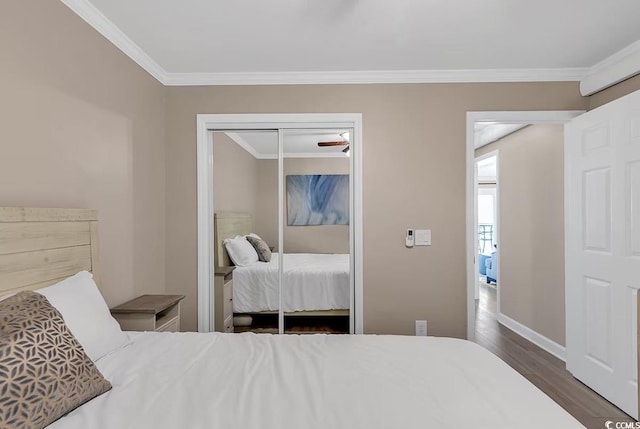 bedroom with dark hardwood / wood-style floors, a closet, and crown molding