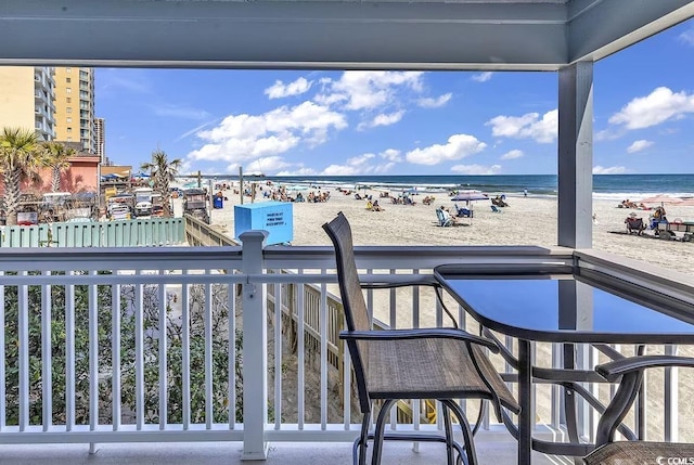 balcony featuring a beach view and a water view