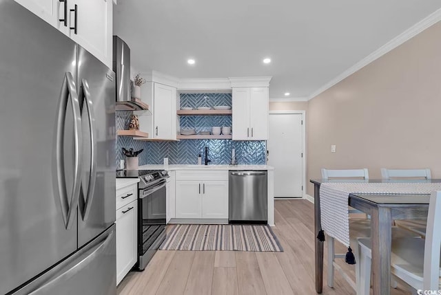 kitchen featuring white cabinetry, stainless steel appliances, wall chimney range hood, backsplash, and light hardwood / wood-style floors