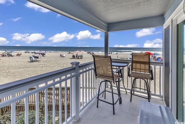 balcony with a beach view and a water view