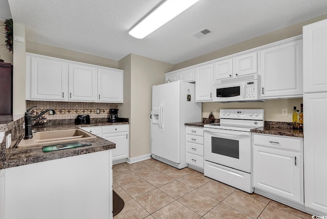 kitchen with white cabinetry, sink, light tile patterned flooring, and white appliances