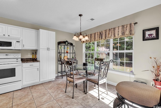 interior space with light tile patterned floors, a textured ceiling, and a notable chandelier