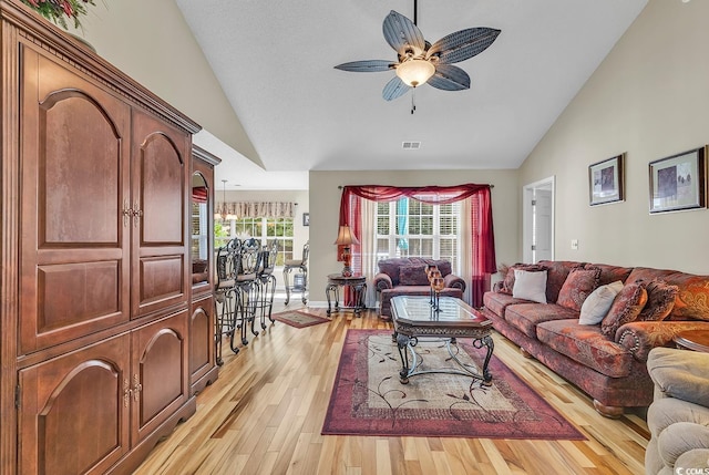 living room featuring ceiling fan, lofted ceiling, and light wood-type flooring