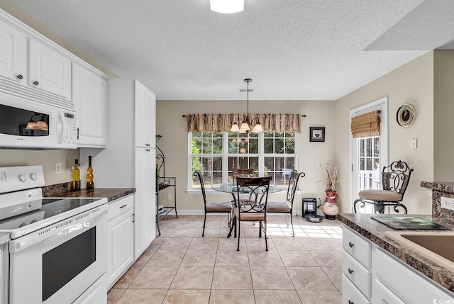 kitchen with pendant lighting, white appliances, light tile patterned floors, white cabinetry, and a chandelier