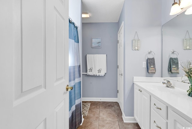 bathroom featuring vanity, a textured ceiling, and tile patterned flooring