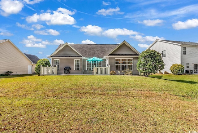 rear view of property featuring a lawn