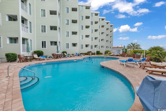 view of pool with area for grilling and a patio