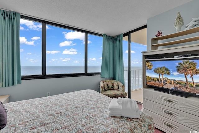 bedroom with a water view and a textured ceiling