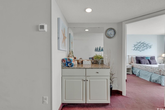 corridor featuring light colored carpet and a textured ceiling