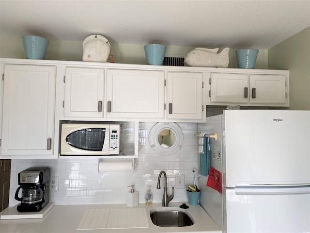 kitchen featuring white cabinets, decorative backsplash, white appliances, and sink