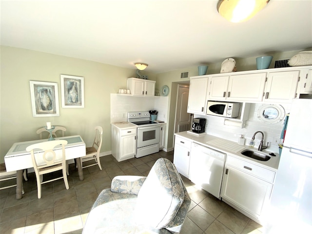 kitchen featuring decorative backsplash, white appliances, white cabinetry, and sink