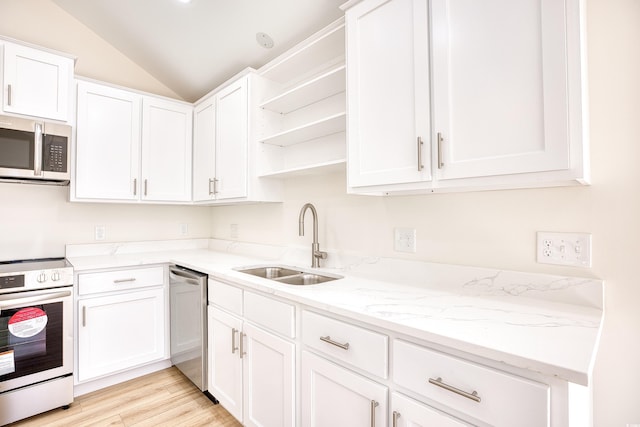 kitchen with white cabinets, vaulted ceiling, stainless steel appliances, open shelves, and a sink