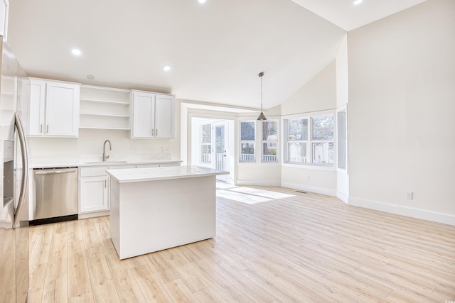 kitchen featuring open shelves, light countertops, appliances with stainless steel finishes, white cabinets, and a sink