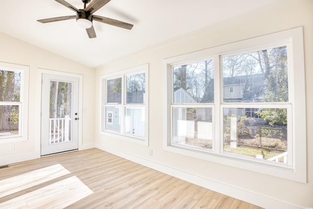 unfurnished sunroom with a healthy amount of sunlight, vaulted ceiling, and visible vents