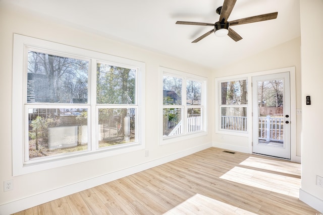 unfurnished sunroom featuring lofted ceiling, visible vents, and a ceiling fan