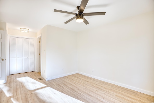 unfurnished bedroom with ceiling fan, a closet, wood finished floors, and baseboards