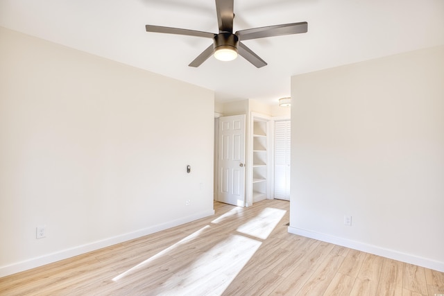 empty room with light wood-style flooring, baseboards, and a ceiling fan