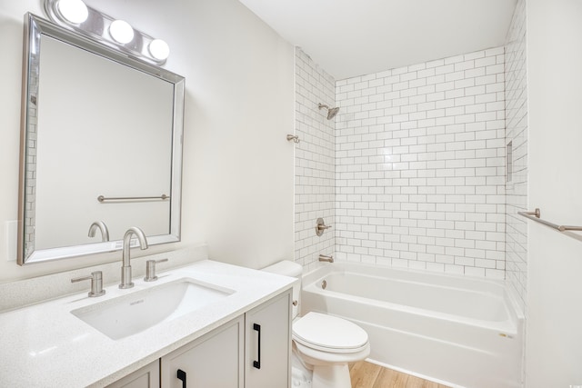 bathroom with wood finished floors, bathing tub / shower combination, toilet, and vanity