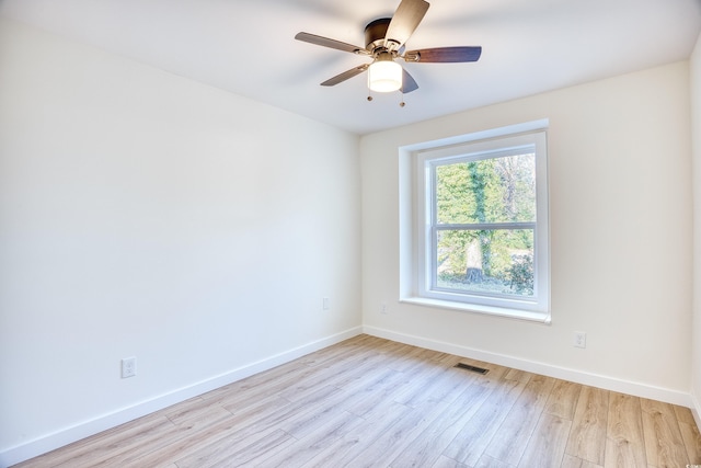 unfurnished room featuring a ceiling fan, light wood-type flooring, visible vents, and baseboards