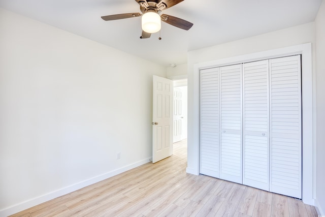 unfurnished bedroom with light wood-style floors, a closet, baseboards, and a ceiling fan