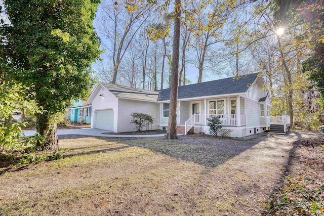 single story home with a garage, covered porch, and driveway