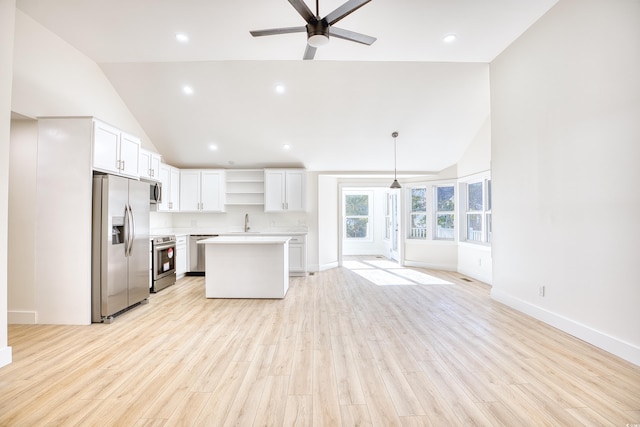 kitchen featuring open shelves, stainless steel appliances, light countertops, open floor plan, and white cabinetry