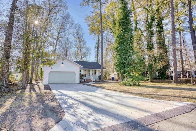 ranch-style home featuring a garage, concrete driveway, and stucco siding