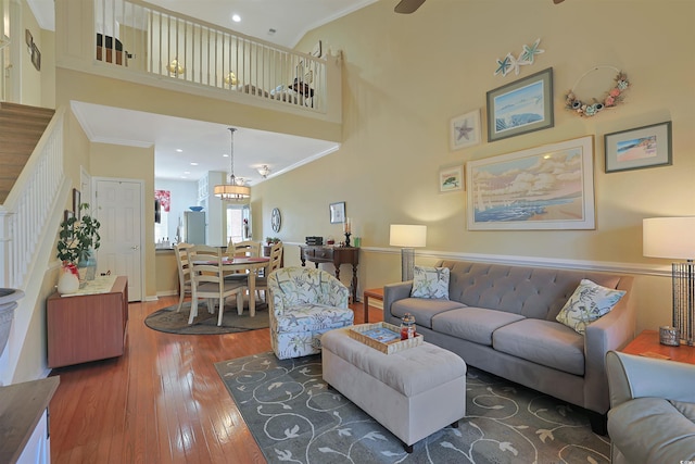 living room with crown molding, a towering ceiling, and dark wood-type flooring