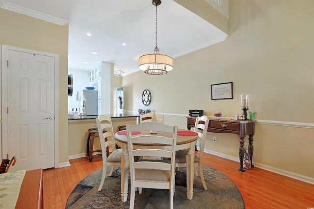 dining area featuring light hardwood / wood-style floors and ornamental molding