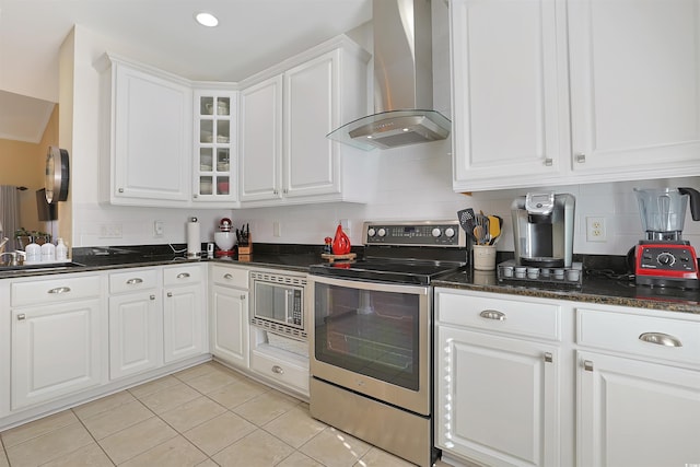 kitchen featuring wall chimney exhaust hood, white cabinetry, stainless steel appliances, and light tile patterned floors